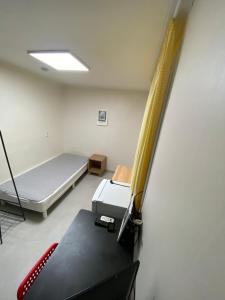 a room with a bed and a table in it at 더스테이365 디럭스 in Seoul +3 photos