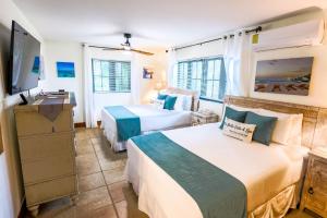 een slaapkamer met twee bedden en een flatscreen-tv bij Alta Bella Villa Private Oceanfront Nordic Spa in Providenciales +42 foto's