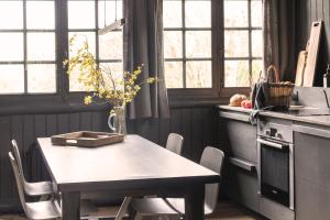 a kitchen with a table with a vase on it at Neska Lodge in Saint-Rémy-lʼHonoré