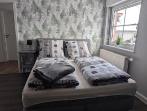 un letto con due cuscini sopra in una stanza di FeWo Luzia a Losheim