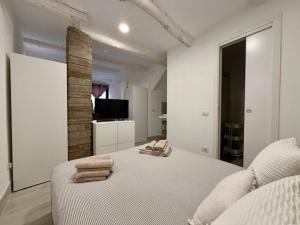 a white bedroom with a bed with towels on it at Lake Suite in Trevignano Romano