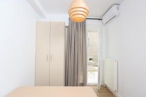 a bedroom with a bed and a light fixture at Samà Housing in Larisa