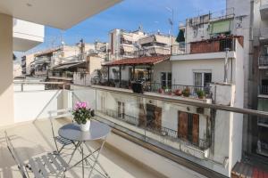 a balcony with a table and chairs and buildings at Samà Housing in Larisa