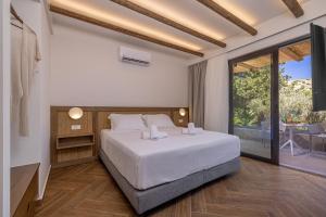 a bedroom with a large bed and a balcony at Avaton Boutique Suites in Vrachonisída touArchangélou +50 photos
