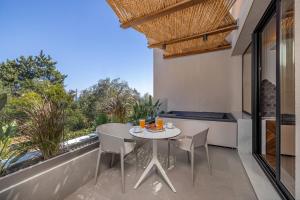 a patio with a table and chairs on a balcony at Avaton Boutique Suites in Vrachonisída touArchangélou