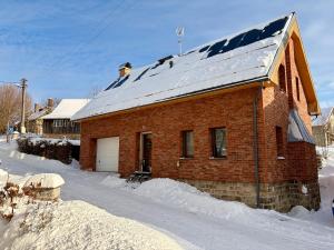 a red brick house with a snow covered roof at Apartmán v Dráze in Zásada
