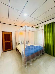 a bedroom with a bed with a canopy at Hiriketiya Lima Homestay in Dickwella