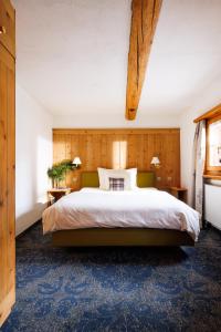 een slaapkamer met een groot bed en een blauw tapijt bij Hotel Chesa Rosatsch - Home of Food in Celerina