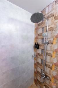 a shower in a bathroom with a stone wall at Desert Rose Village in Al Khatim