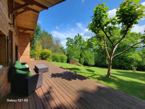 a wooden deck with a bench and a tree at Le Barail 31 in Couret +7 photos