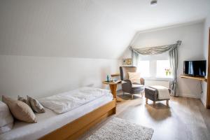 een slaapkamer met een bed, een bureau en een stoel bij Forellenhof Poggel in Eslohe