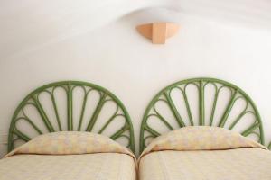 two beds with green headboards in a bedroom at Résidence hôtelière Le Provençal à Giens - Bord de mer in Hyères +56 photos