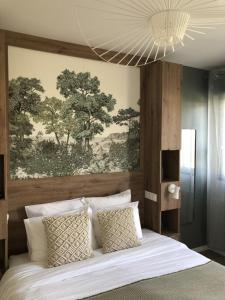 a bedroom with a white bed with a painting on the wall at Les clés d'à côté - maison d'hôtes de charme près de Rouen in Sotteville-lès-Rouen
