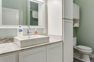 a white bathroom with a sink and a toilet at Historic Elegance Modern Amenities Gym in Louisville