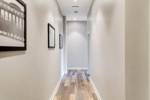 a hallway with white walls and wood flooring at Historic Elegance Modern Amenities Gym in Louisville