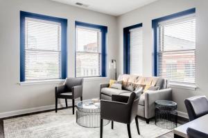 a living room with a couch and chairs and windows at Historic Elegance Modern Amenities Gym in Louisville +19 photos
