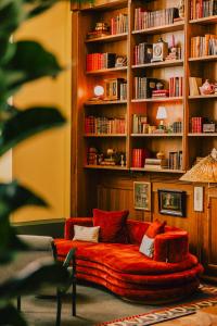 a living room with a red couch in front of a book shelf at Wilde Vienna Fleischmarkt in Vienna +146 photos