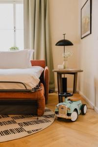 een slaapkamer met een speelgoedauto op de vloer naast een bed bij Wilde Vienna Fleischmarkt in Wenen