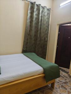a bed in a room with a curtain and a door at TATAICHA Appart in NʼDjamena