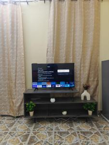 a flat screen tv sitting on top of a dresser at TATAICHA Appart in NʼDjamena