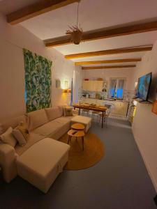 a living room with a couch and a table at OIKOS Guesthouse & Rooftop in Suio