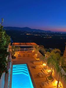 a resort with a swimming pool and lounge chairs at OIKOS Guesthouse & Rooftop in Suio