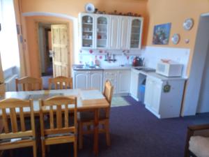 a kitchen with a table and chairs and a sink at Apartmány Somora in Doksy +2 photos