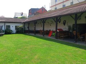 a patio with tables and chairs in a yard at Apartmány Somora in Doksy