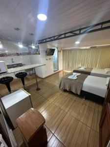 a large bedroom with a bed and a kitchen at Hotel Araras in Manaus