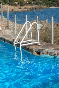 a white slide in a pool of water at Résidence hôtelière Le Provençal à Giens - Bord de mer in Hyères