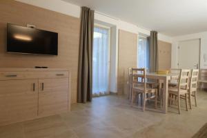 una cucina e una sala da pranzo con tavolo e sedie di Appartamento Alpen Molveno a Molveno