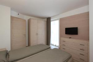 una camera da letto con un letto e una TV a schermo piatto di Appartamento Alpen Molveno a Molveno