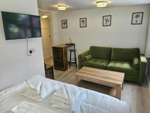 a living room with a green couch and a table at The Tobermory Hotel in Tobermory