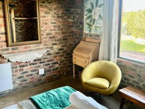 a living room with a yellow chair and a dresser at De Krantz 6 Estate in Clarens