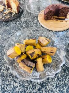 a glass bowl of food on a table with a cake at Hotel Dairy Walley in Itapetinga