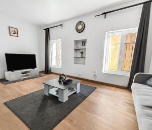 a living room with a couch and a tv at Central, spacieux et calme votre cocon à Melun in Melun
