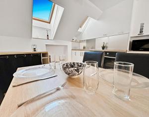 a wooden table with glasses on it in a kitchen at Central, spacieux et calme votre cocon à Melun in Melun