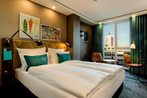 een hotelkamer met een groot bed en een raam bij Motel One Leipzig-Post in Leipzig
