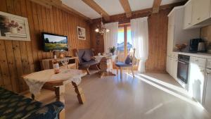 a living room with a table and chairs and a kitchen at Ferienhaus Alpenzauber in Krün