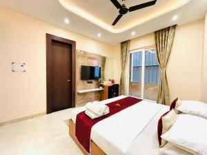a bedroom with a large bed and a tv at Goel Villa and Hotel in Allāhābād Junction