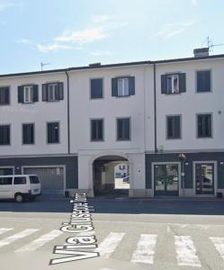 a large white building with a parking lot in front of it at Duca - Gorizia City Apartment - 80 smq Central in Gorizia