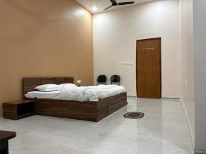 a bedroom with a large bed with a wooden headboard at ENERGY Inn in Kotri Kalān