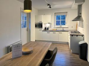 a large kitchen with a wooden table in a room at Summio Villaparc Schoonhovenseland in Hollandscheveld