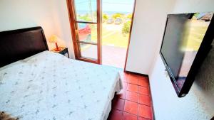 a bedroom with a bed and a door to a patio at Lo de las Tías in Balneario Solís