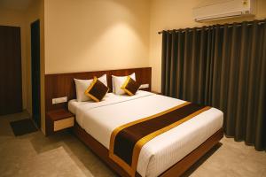 a bedroom with a large bed in a room at Hotel Shree Abhishek in Bārāmati +1 photo