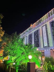 a large building with green lights on it at night at Hotel Shree Abhishek in Bārāmati