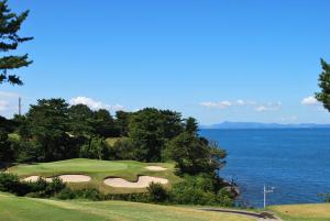 a golf course with a view of the ocean at つるふく in Misaki