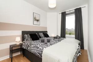 una camera da letto con un letto bianco e nero e una finestra di Free Parking - Central - Dunfermline Sleeps 4 a Dunfermline