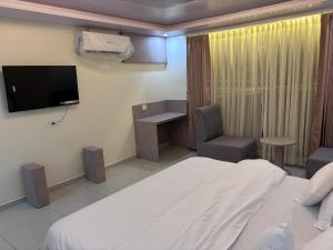 a hotel room with a bed and a tv and a chair at NR Hotel in Rīngas +19 photos