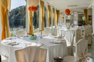 een kamer met witte tafels en stoelen met ballonnen bij Grand Hotel Il Ninfeo in Gaeta